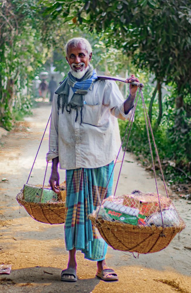 Rohingya man carrying baskets, highlighting scabies outbreak for refugees that fled Myanmar